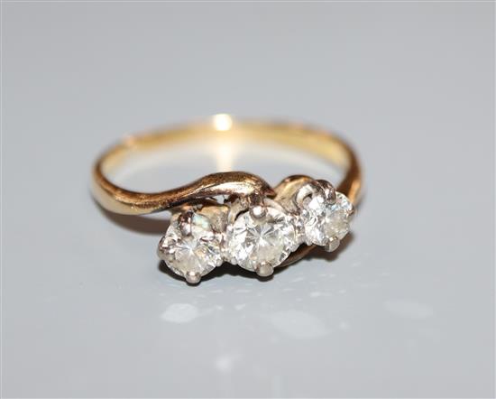 A yellow metal and plat, three stone diamond crossover ring, size N.
